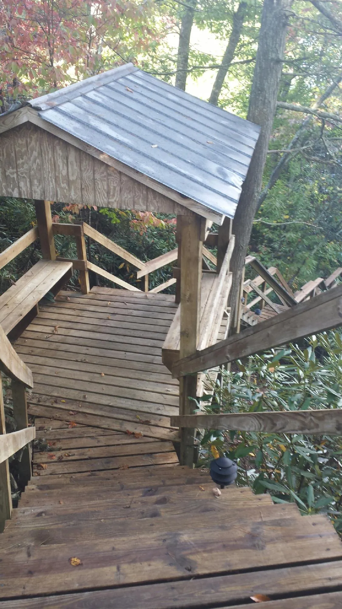 Metal roofed shelter over wooden steps on a wooded walkway — Skylight Repair & Installation work by our crew in Fairchild Air Force Base
