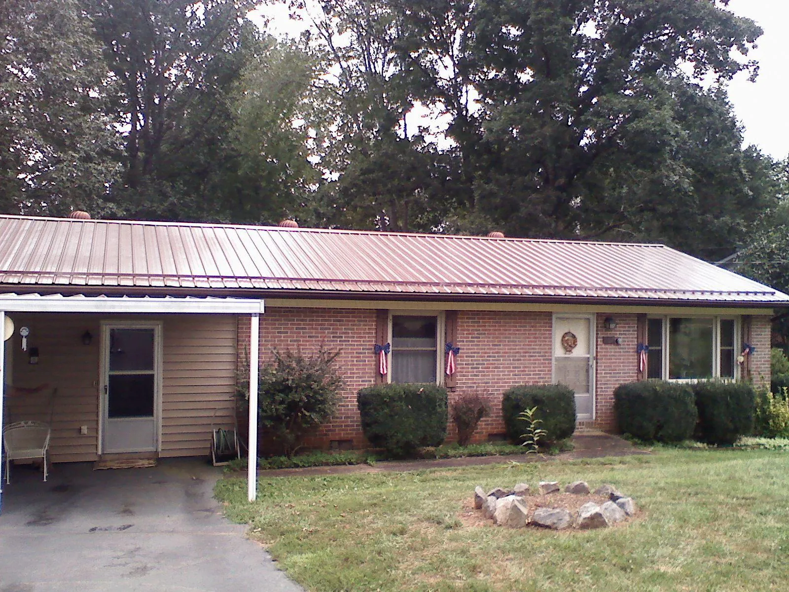 Bronze metal roof and carport on a brick ranch home — Roof Repair work by our crew in Fairchild Air Force Base