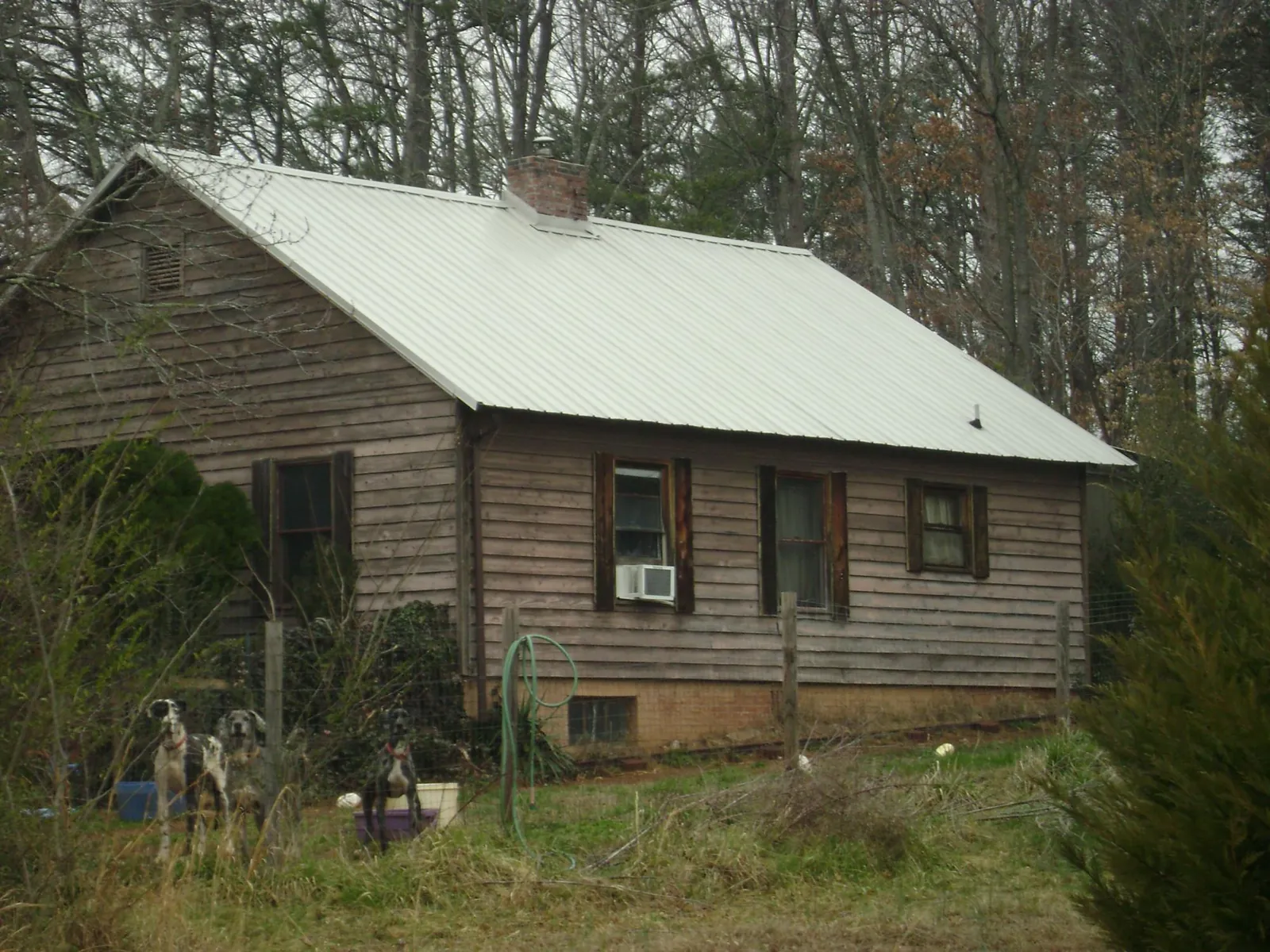 White metal roof on an old wood sided farmhouse, from a Asphalt Shingle Roof Repair job in Fairchild Air Force Base
